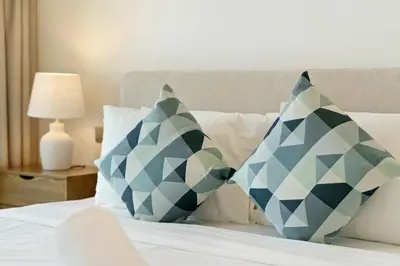 a bedroom with blue and white pillows on a bed at Elegant 2BR in Beachfront with Stunning Marina Views in Dubai
