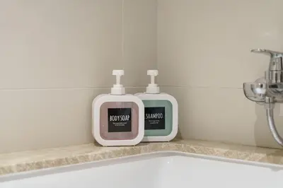 two bottles of soap sitting next to a bathroom sink at Elegant 2BR in Beachfront with Stunning Marina Views in Dubai