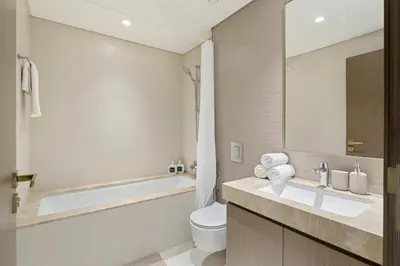 a bathroom with a tub and a toilet and a sink at Elegant 2BR in Beachfront with Stunning Marina Views in Dubai