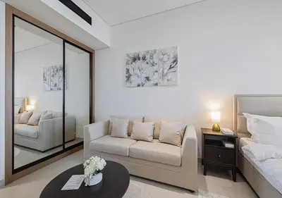 a living room with a couch and a bed at Livin' Holidays - Studio - Canal view with jacuzzi in Dubai