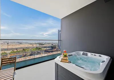 a bathroom with a bath tub and a large window at Livin' Holidays - Studio - Canal view with jacuzzi in Dubai