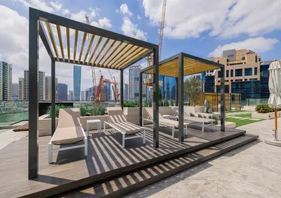 a gazebo with chairs and tables on a rooftop at Livin' Holidays - Studio - Canal view with jacuzzi in Dubai