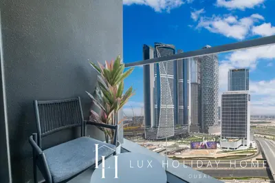 a chair on a balcony with a view of a city at LUX The Northside Studio in Dubai