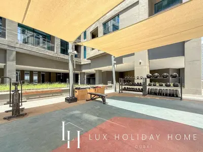 a building with a bench and a sign for luz holiday home at LUX The Northside Studio in Dubai