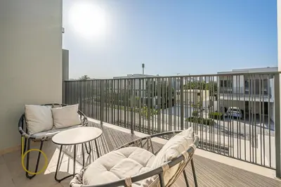 a balcony with two chairs and a table on a balcony at Bookable - 4 Bedroom Elan 1 Tilal Al Ghaf Villa in Dubai