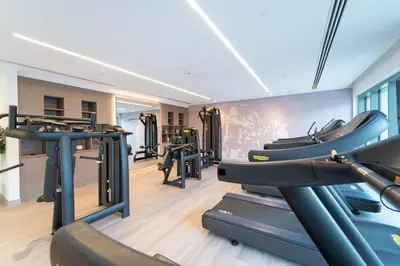 a gym with treadmills and elliptical machines at Luxury 3BR, MaidRoom Full Burj & Fountain Views in Dubai