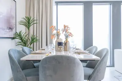 a dining room with a table and chairs at Luxury 3BR, MaidRoom Full Burj & Fountain Views in Dubai