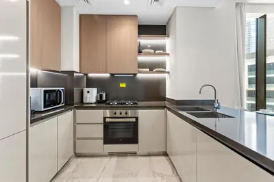 a kitchen with a stove and a microwave at Lavish 1-Bedroom with Burj Khalifa view in Peninsula in Dubai