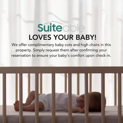 a baby laying on a bed in a crib at Lavish 1-Bedroom with Burj Khalifa view in Peninsula in Dubai