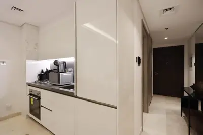 a kitchen with white walls and a stove top oven at Modern Studio Near Dubai Mall Walk to Dubai Canal in Dubai