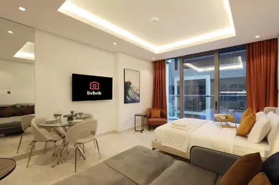 a hotel room with a king sized bed and a living room at Modern Studio Near Dubai Mall Walk to Dubai Canal in Dubai