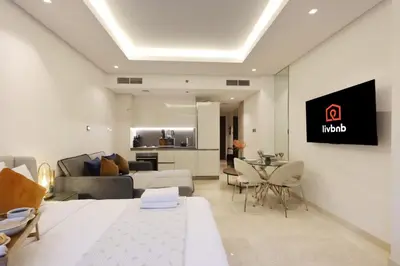 a hotel room with a king sized bed and a living room at Modern Studio Near Dubai Mall Walk to Dubai Canal in Dubai
