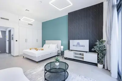 a living room with a bed and a tv at Modern Home in Sports City with Rooftop Pool in Dubai