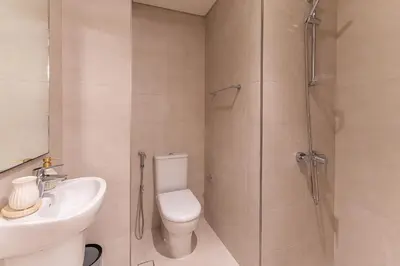 a bathroom with a shower and a toilet and a sink at HAVN - Luxurious 4 Bed Villa in Arabian Ranches 3 in Dubai