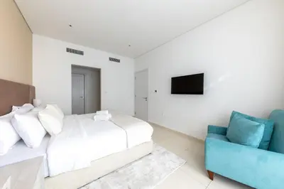 a bedroom with a bed and a blue couch at Stylish One-Bedroom Oasis - Prime Palm Location in Dubai