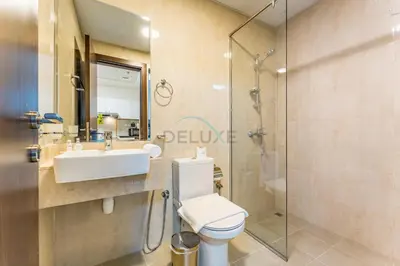 a bathroom with a toilet and a sink and a shower at Pool View 1BR with Spacious Balcony, Short Drive to Downtown, Binghatti Gateway, Al Jaddaf by Deluxe Holiday Homes in Dubai