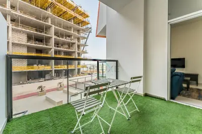 a balcony with a table and chairs in a building at Pool View 1BR with Spacious Balcony, Short Drive to Downtown, Binghatti Gateway, Al Jaddaf by Deluxe Holiday Homes in Dubai