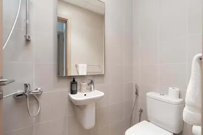a white bathroom with a toilet and a sink at Luxury 2BR and Study Water View in Al Wasl in Dubai