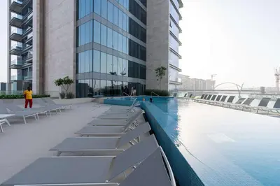 a building with a swimming pool in front of a building at Luxury 2BR and Study Water View in Al Wasl in Dubai