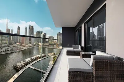 a balcony of a building with a view of a river at Luxury 2BR with Canal View Burj Khalifa view and Infinity Pool Access in Dubai