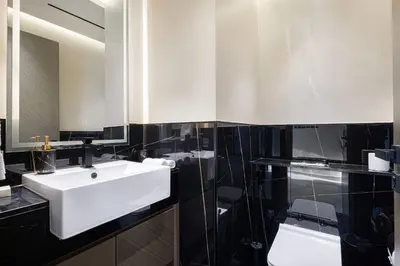 a bathroom with a white sink and a mirror at Luxury 2BR with Canal View Burj Khalifa view and Infinity Pool Access in Dubai