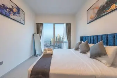 a bedroom with a large bed with a large window at Stunning Burj Khalifa & Fountain Views in Dubai