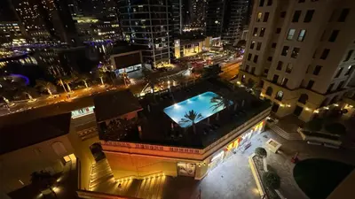 an overhead view of a city at night with a pool at Marina View Luxury Retreat Modern Apartment JBR Dubai in Dubai