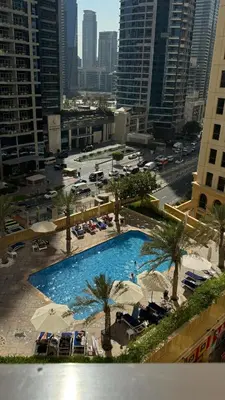a large swimming pool with umbrellas in a city at Marina View Luxury Retreat Modern Apartment JBR Dubai in Dubai