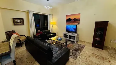 a living room with a person sitting on a couch at Marina View Luxury Retreat Modern Apartment JBR Dubai in Dubai