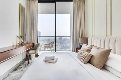 a bedroom with a large white bed with a large window at GuestReady - Stunning unit at Binghatti House in Dubai