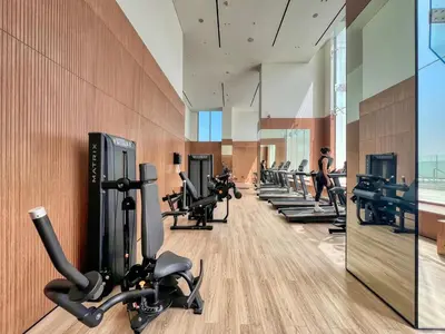 a gym with a row of treadmills and machines at GuestReady - Stunning unit at Binghatti House in Dubai
