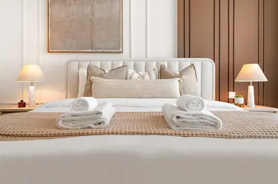 a bedroom with a white bed with towels on it at Silkhaus Charming 1BDR in Canal Front Tower in Dubai