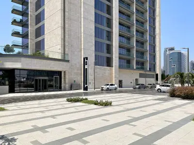a parking lot with cars parked in front of a building at Silkhaus Elite 1BDR in Canal Front Tower in Dubai
