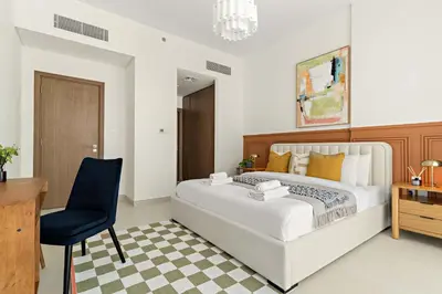 a bedroom with a bed and a desk and a chair at Silkhaus Luxury 1BDR Stay in Canal Front, Al Wasl in Dubai