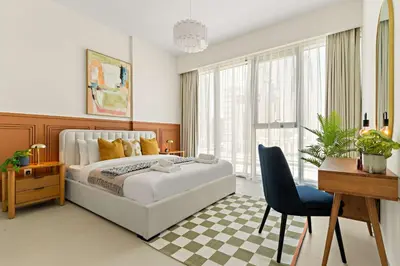 a bedroom with a bed and a desk and a chair at Silkhaus Luxury 1BDR Stay in Canal Front, Al Wasl in Dubai