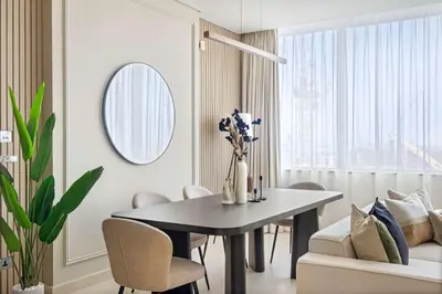 a dining room with a table and chairs and a mirror at Silkhaus Cityscape 1BR in Sky Gardens with Metro access in Dubai