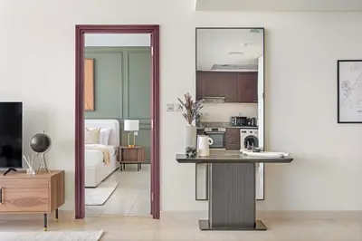 a living room with a table and a mirror at Silkhaus Cityscape 1BR in Sky Gardens with Metro access in Dubai