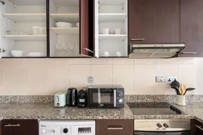 a kitchen counter with a microwave and a coffee maker at Silkhaus Elegant 1BDR in Sky gardens with Metro Access in Dubai