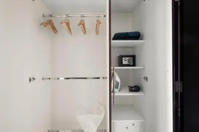 a bathroom with white walls and white shelves at Silkhaus Elegant 1BDR in Sky gardens with Metro Access in Dubai