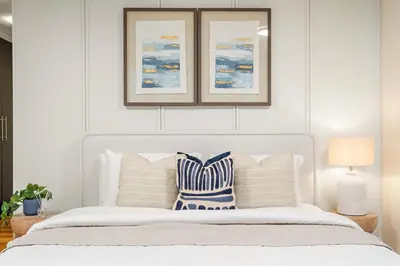 a bedroom with a white bed with blue and white pillows at Silkhaus Exclusive 1BDR Stay at Sky Gardens in DIFC in Dubai