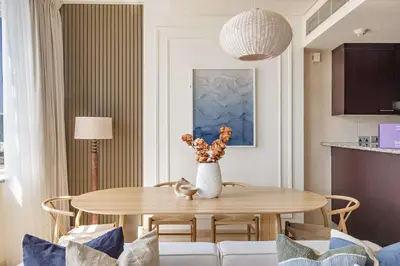 a dining room with a table and a vase with flowers at Silkhaus Exclusive 1BDR Stay at Sky Gardens in DIFC in Dubai