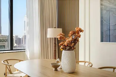 a white vase with flowers sitting on a table at Silkhaus Exclusive 1BDR Stay at Sky Gardens in DIFC in Dubai