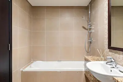 a bathroom with a bath tub and a sink at Silkhaus Urban 1BDR Escape in Heart of DIFC in Dubai