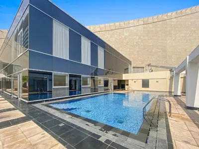 a large building with a swimming pool in front of it at Silkhaus Urban 1BDR Escape in Heart of DIFC in Dubai