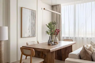 a living room with a wooden table and chairs at Silkhaus Urban 1BDR Escape in Heart of DIFC in Dubai
