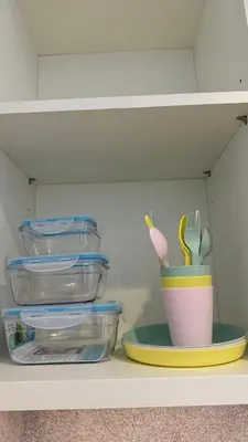 a shelf with plastic containers and a cup on a plate at Luxury 2BR Downtown ,5 min walk to Burj Khalifa and Dubai Mall in Dubai
