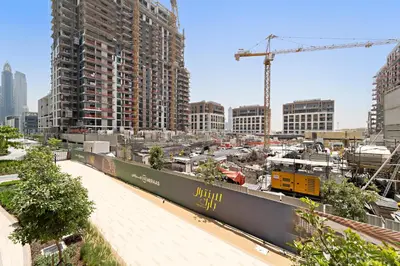 a train yard in a city with tall buildings at 3BR Central Park, Prime Dubai Location in Dubai