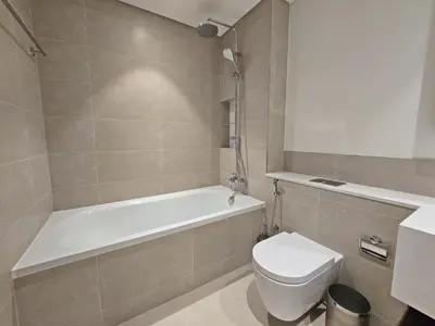 a bathroom with a toilet and a tub and a sink at Brand New 1BR , Fully Furnished in Dubai