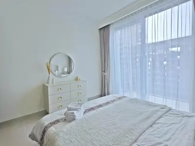 a bedroom with a bed and a mirror and a window at Brand New 1BR , Fully Furnished in Dubai
