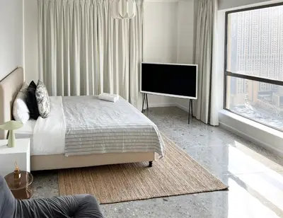 a bedroom with a bed and a flat screen tv at Fav 2-Bedroom by The Beach in JBR Bahar with stunning Marina View in Dubai